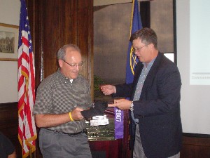 Capt. Bob Whitkop, USN (Ret) (r), presents Huskey with mementos of thanks in recognition of his vist to the chapter in July.